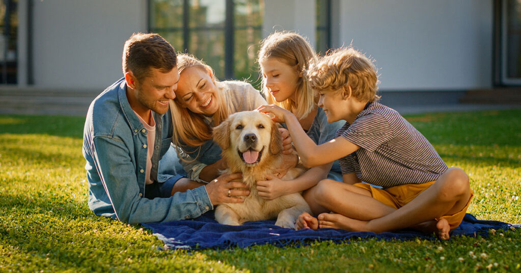 Glückliche Familie im Garten mit Hund
